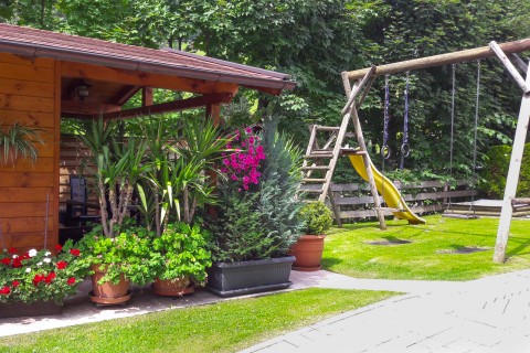 Foto Gartenhaus mit Spielplatz im Sommer